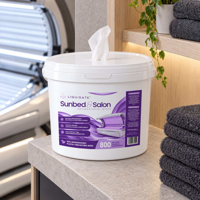 Liquidate® Sunbed & Salon antibacterial wipes in a white plastic bucket with purple label and pop-up white sheet.