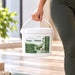 Biodegradable antibacterial wipes in a white bucket with green label and handle, Liquidate® Yoga & Pilates 500-sheet pack.
